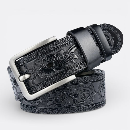 Le Monde de la Ceinture black leather belt with intricate embossed tribal floral pattern and silver buckle.