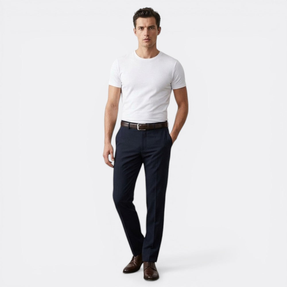 Le monde de la ceinture men's dark brown leather belt with silver buckle, paired with navy trousers and a white t-shirt.