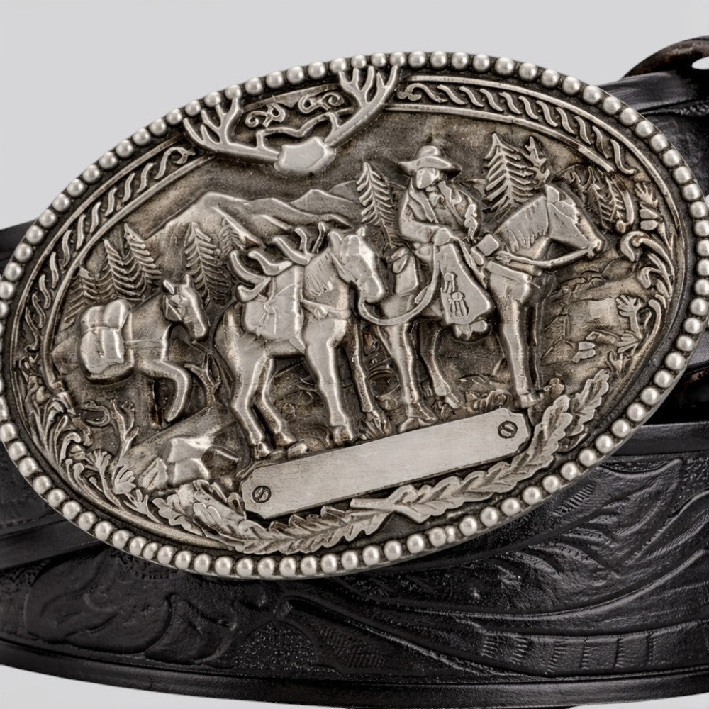 Le monde de la ceinture men's vintage leather belt with ornate silver buckle depicting cowboys and horses.