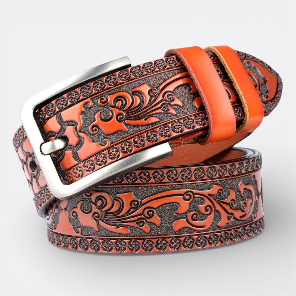 Le monde de la ceinture orange leather belt with intricate tribal embossed pattern and silver buckle.